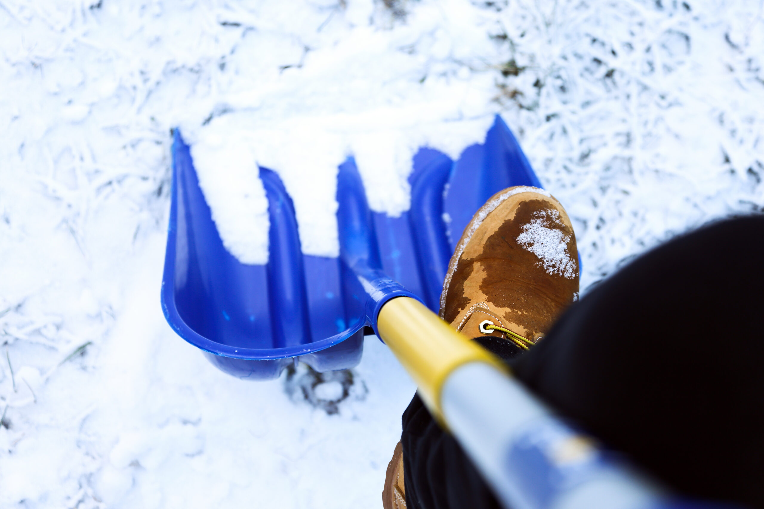Man worker in uniform ,shoveling snow . close up image